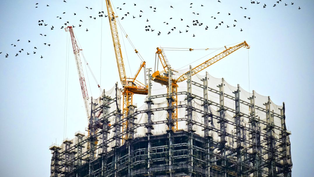 Construction insurance, building with cranes.